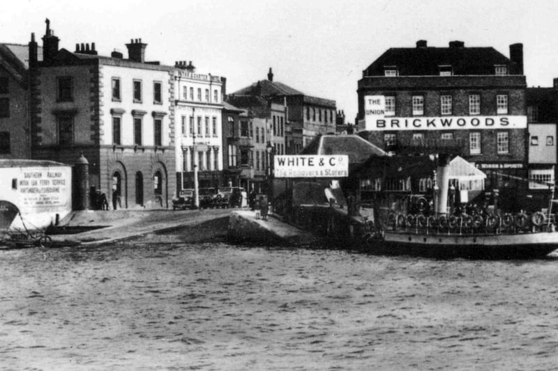 The Point Old Portsmouth. All the buildings to the left have now been demolished. The Brickwoods pub The Union is now The Spice Island Inn.
The notice to the left states: Southern Railway. Motor car Ferry Service - Portsmouth to Fishbourne. There's the sign for White & Co Removers and Storers and The Union the Brickwoods pub to the right, with people on the slip way about to board the ferry.