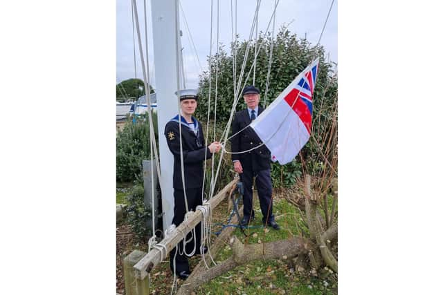 Junior rating Kyle Christie and Ian Grant prepare to hoist the White Ensign at HISC 80 years after the sailing club officially became the wartime HQ for COPP. Picture by Leonie Austin
