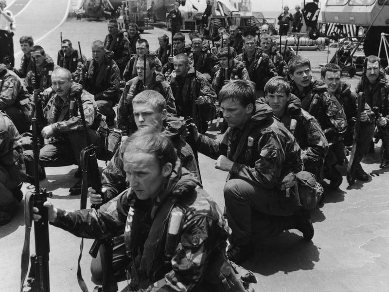 Royal Marines waiting on the flight deck of HMS Hermes for Sea King helicopters to take them on training manoeuvres, April 1982.