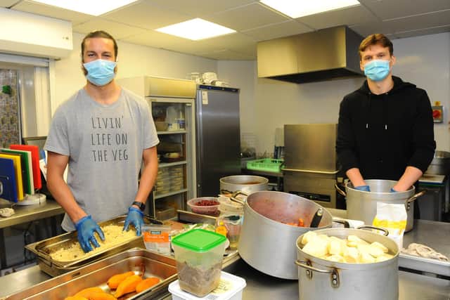 Portsmouth FC players Christian Burgess and Sean Raggett helping out in the kitchen at Landport Community Centre. Picture: Sarah Standing (300420-8145)