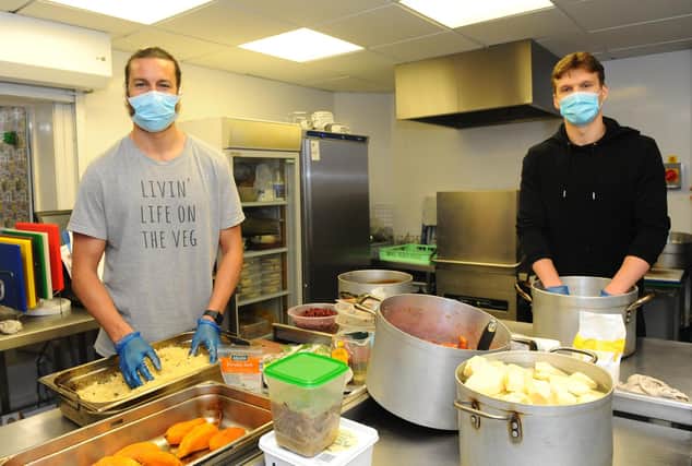 Portsmouth FC players Christian Burgess and Sean Raggett helping out in the kitchen at Landport Community Centre. Picture: Sarah Standing (300420-8145)
