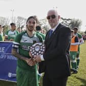 Connor Hoare receives the Wessex League Division 1 play-off trophy after his side's penalty shoot-out win at New Milton. Picture by Robin Caddy.