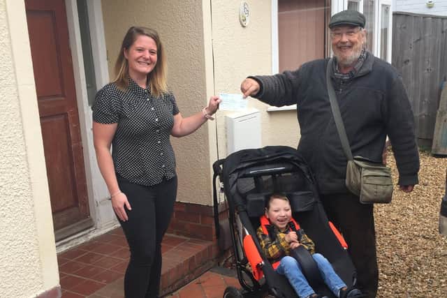 Stephen Foster presents a cheque for £3,500 to Finlay Montague and his mum Nicola.