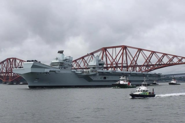 HMS Queen Elizabeth leaving Rosyth in Fife, Scotland, and sailing under the Forth bridge. She is due to return home to Portsmouth on July 30.