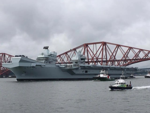 HMS Queen Elizabeth leaving Rosyth in Fife, Scotland, and sailing under the Forth bridge. She is due to return home to Portsmouth on July 30.