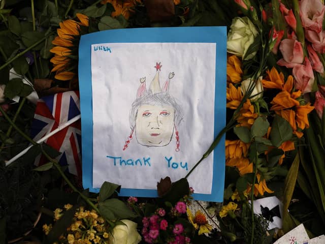 A child's hand-drawn image of Queen Elizabeth II lays among the thousands of flower bouquets that have been left in tribute to the queen, who died last week, on September 12, 2022 in London. Picture: Chip Somodevilla/Getty Images.