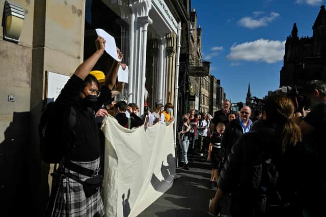 Anti-Royalist protesters hold up blank placards in a demonstration against the way their protests are being policed, in Edinburgh, today following the death of Queen Elizabeth II on September 8. Picture: Louisa Gouliamaki / AFP via Getty Images.
