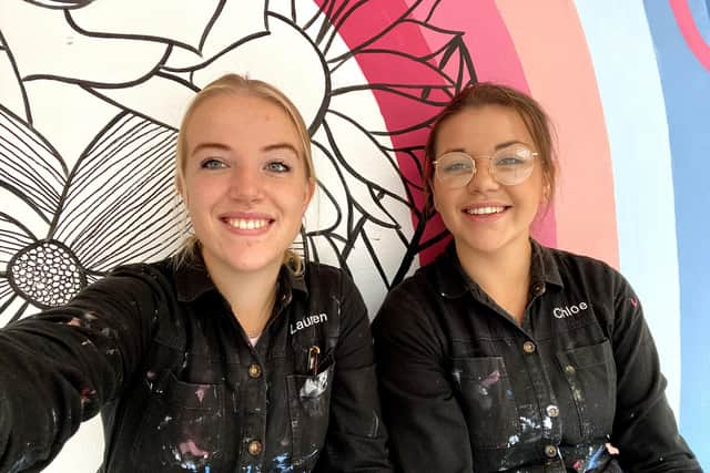Lauren, left, and Chloe Piper, of 2 Sisters, in front of their mural at Portsmouth Creates market, Southsea.
