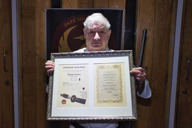 Members of PSKO Havant presented a gift of a Katana of Hope to instructor Michael Fletcher with a certificate and poem. Pictured: Sensei Fletcher with the certificate and poem