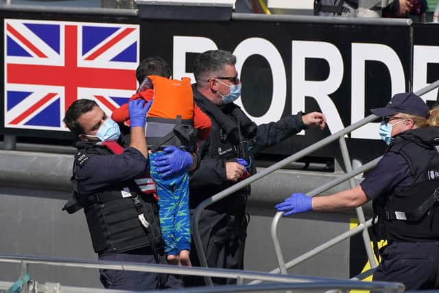 Border Force officers help a young child brought in to Dover, Kent, with a group of people thought to be migrants following a small boat incident in the Channel. Picture date: Wednesday September 8, 2021.