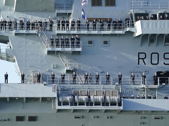 Sailors line up on the side of the Royal Navy aircraft carrier HMS Prince of Wales as it returns to Portsmouth Naval Base following a three-month deployment to the Eastern Seaboard of the United States, where the Prince of Wales has been undergoing trials and operating with aircraft and drones. Picture: Andrew Matthews/PA Wire