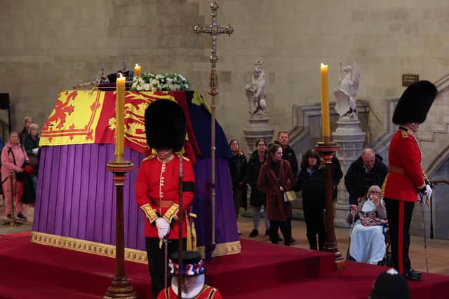 Members of the public view the coffin of Queen Elizabeth II, lying in state on the catafalque in Westminster Hall, at the Palace of Westminster, London, ahead of her funeral on Monday. Picture: Adrian Dennis/PA Images.