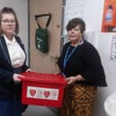 Castle View Academy Year 10 pupil, Ellie Cotton-Trevarth and medical welfare officer, Janette Levers, alongside the red box which provides free sanitary products and underwear for girls suffering from period poverty.