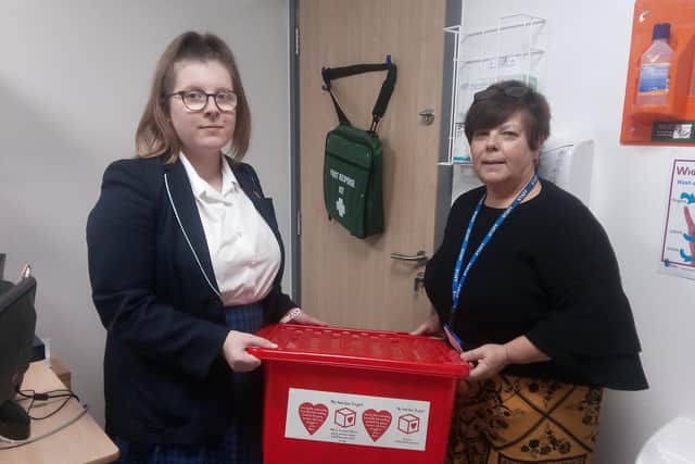 Castle View Academy Year 10 pupil, Ellie Cotton-Trevarth and medical welfare officer, Janette Levers, alongside the red box which provides free sanitary products and underwear for girls suffering from period poverty.