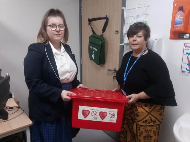 Castle View Academy Year 10 pupil, Ellie Cotton-Trevarth and medical welfare officer, Janette Levers, alongside the red box which provides free sanitary products and underwear for girls suffering from period poverty.