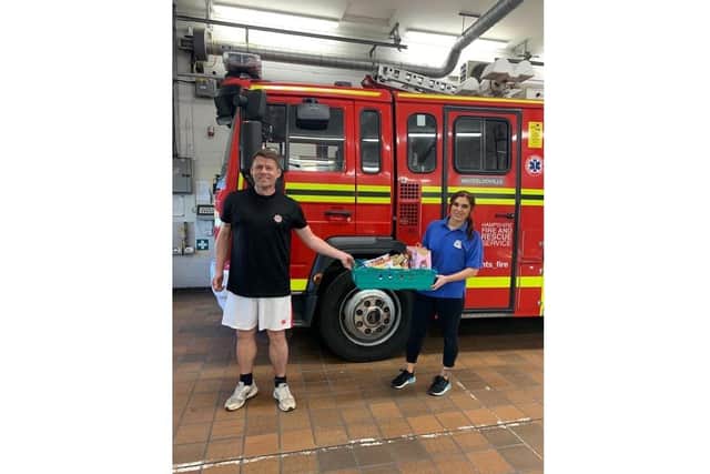 Growing Places staff member Adele Tindall-Barber handing over a hamper to fireman Craig Sadler