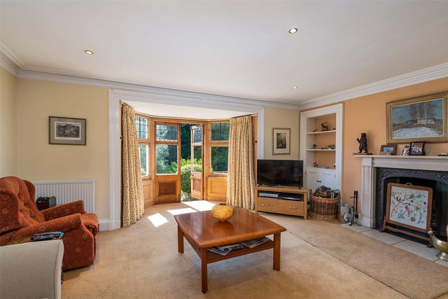 The large living room has an original fireplace and doors out to the garden.
