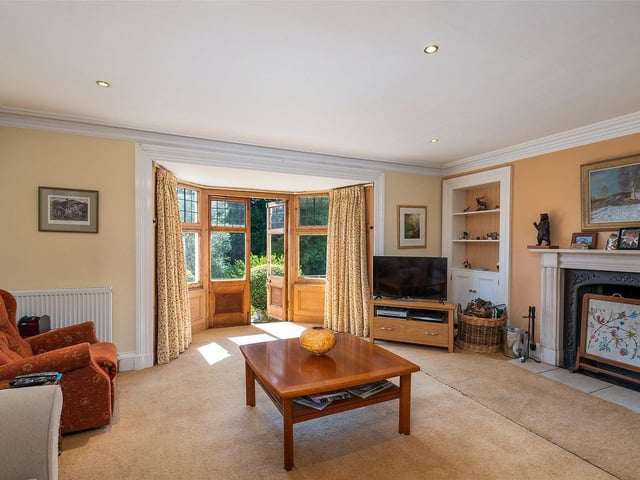 The large living room has an original fireplace and doors out to the garden.