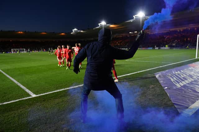 A Wigan fan celebrates with a flare after Callum Lang's last-minute winner against Plymouth at Home Park last month. Picture: Dan Mullan/Getty Images