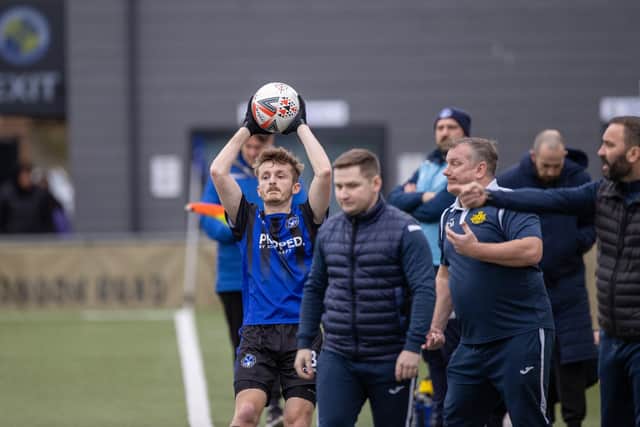 Clanfield's Sonny Locke takes a throw in in front of the Moneyfields bench. Picture: Alex Shute