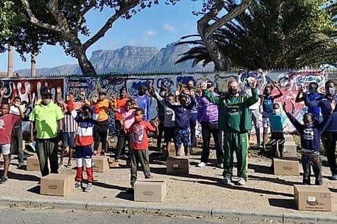 South African families with some of the food hampers that have been donated through the initiative set up the Veterans Cricket Association of South Africa.