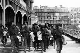 Soldiers walk along South Parade Pier to embark for Normandy.