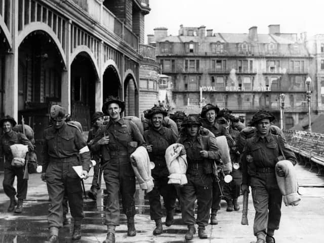 Soldiers walk along South Parade Pier to embark for Normandy.