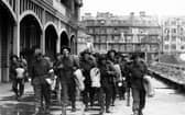 Soldiers walk along South Parade Pier to embark for Normandy.