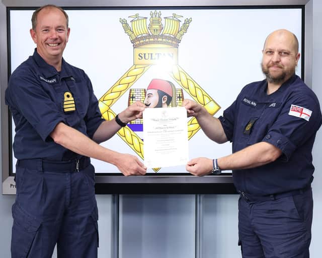 Commanding Officer HMS Sultan, Captain John Voyce RN, presents the Royal Humane Society certificate to CPOET(ME) Stew Jayes.
