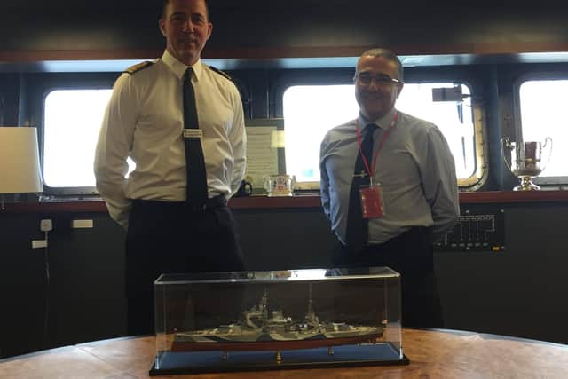 Captain Angus Essenhigh, commanding officer of HMS Queen Elizabeth, pictured left, with RAF veteran Richard Stewart, right, and his model of the former battleship HMS Queen Elizabeth, front.