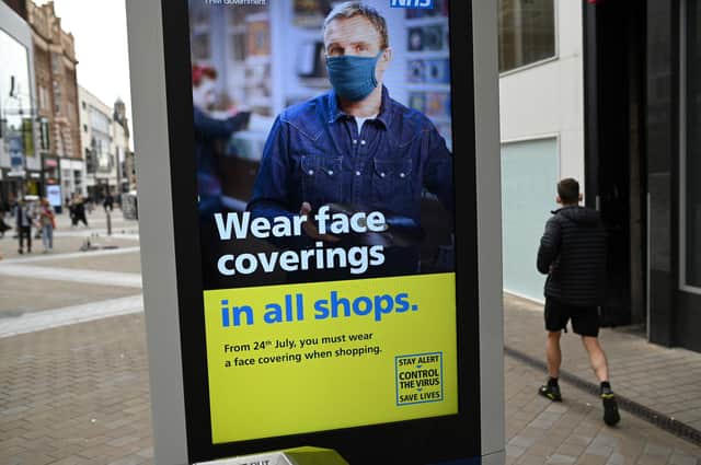A sign calling for the wearing of face coverings in shops. Photo by Oli Scarff / AFP via Getty Images