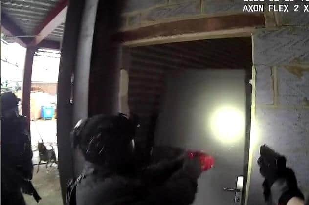 Firearms officers entering premises in Tottenham just before the arrests made after 2.3 tonnes of cocaine was found at Portsmouth port.