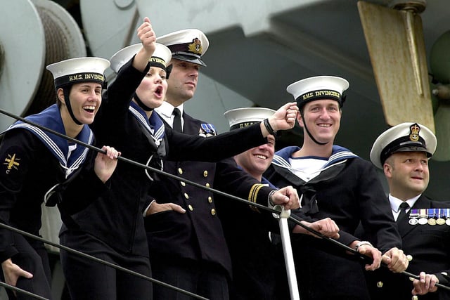 Sailors wave at loved ones waiting for them as HMS Invincible comes into Portsmouth Harbour after major exercises off the eastern United States and a flag flying visit to New York. 16th July 2004. Picture: Matt Scott-Joynt (043591-14)