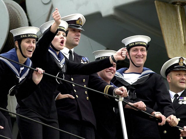Sailors wave at loved ones waiting for them as HMS Invincible comes into Portsmouth Harbour after major exercises off the eastern United States and a flag flying visit to New York. 16th July 2004. Picture: Matt Scott-Joynt (043591-14)