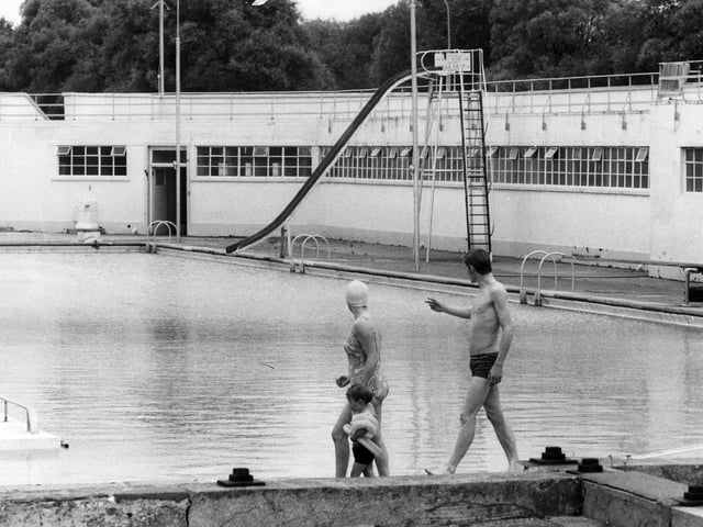 Swimmers walk past the pool in August 1972