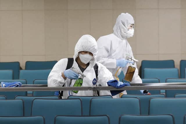 Workers in protective suits spray disinfectant as a precaution against the COVID-19 at an indoor gymnasium in Seoul, South Korea. Picture: AP Photo/Lee Jin-man