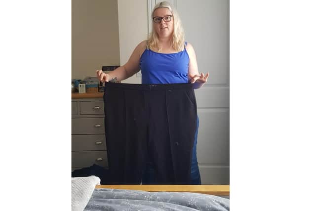 Kat Atrill from Waterlooville has lost 5 stone with Slimming World by 'doing it for herself'. Pictured: Kat posing with an old pair of size 24 trousers