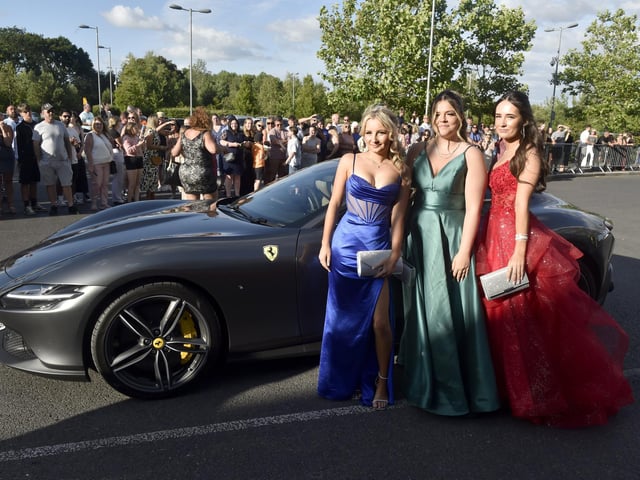 A group of friends pose in front of Ferrari as friends and family watch on.Picture: Sarah Standing (270624-5743)