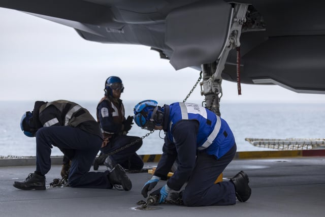 Pictured: Aircraft handlers secure an F35-B to the flight deck.