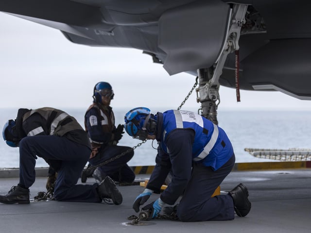 Pictured: Aircraft handlers secure an F35-B to the flight deck.