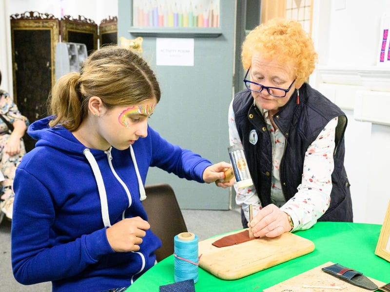 Pictured is: Louisa try out leather craft with Toni Brannon
Picture: Keith Woodland (170721-21)