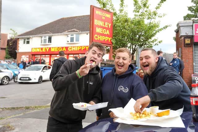 From left, Jake, Tom and Josh from Portsmouth eating their chips outside Binley Mega Chippy in Coventry Picture: SWNS