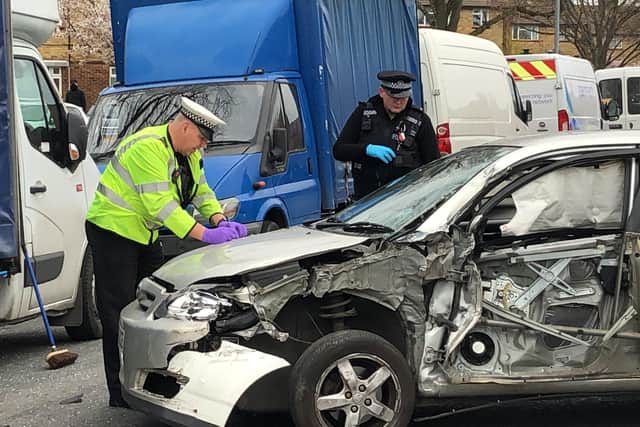 A car crashed in Northern Parade, Hilsea, leaving one person with chest injuries. Pictured: Officers assess the damage. Photo: Tom Cotterill