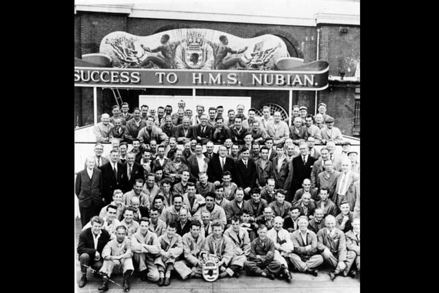 Dockyard workers after the completion of HMS Nubian in 1960. 
HMS Nubian (F131) was a Tribal-class frigate of the Royal Navy, built by Portsmouth Dockyard, at a cost of £4,360,000. She was launched on 6 September 1960 by Lady Holland-Martin, wife of Vice-Admiral Sir Deric Holland-Martin, and commissioned on 9 October 1962. 
Picture: Dockyard Historical Society.