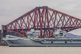 HMS Queen Elizabeth makes her way under the Forth Bridges as she prepares to dock at Rosyth dockyard for repairs, March 21 2024.
