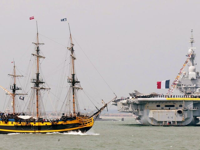 Tall ship The Grand Turk (foreground) passes by French aircraft carrier FS Charles de Gaulle during the International Fleet Review at Spithead, off Portsmouth, Tuesday June 28, 2005. A total of 167 ships from the Royal Navy and 35 nations are taking part in the International Fleet Review at Spithead, off Portsmouth, as part of the Trafalgar 200 celebrations this week. See PA Story SEA Trafalgar. PRESS ASSOCIATION Photo. Photo credit should read: Gareth Fuller/PA
