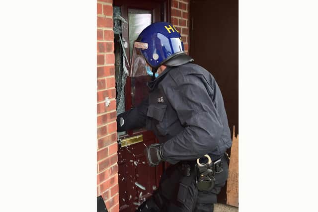 Police officers gain entry to a property following an ongoing investigation into drug related criminal activity across the city.