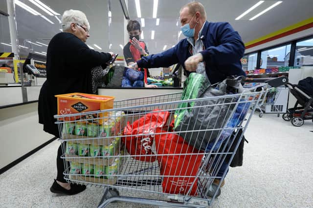 Mandy and Brian Tracey load their shopping into a trolley at a checkout. Farmfoods on Fratton Rd has reopened after being refurbishedPicture: Chris Moorhouse      (121220-03)