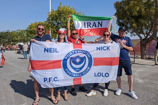Neil Smale and his family with the bespoke Pompey flag in Qatar.