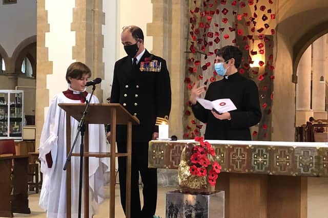 Captain Angus Essenhigh, commanding officer of HMS Queen Elizabeth watches over his son Artemis, 11, who is a chorister at the Portsmouth Cathedral and will be performing at the service. Picture: Tom Cotterill